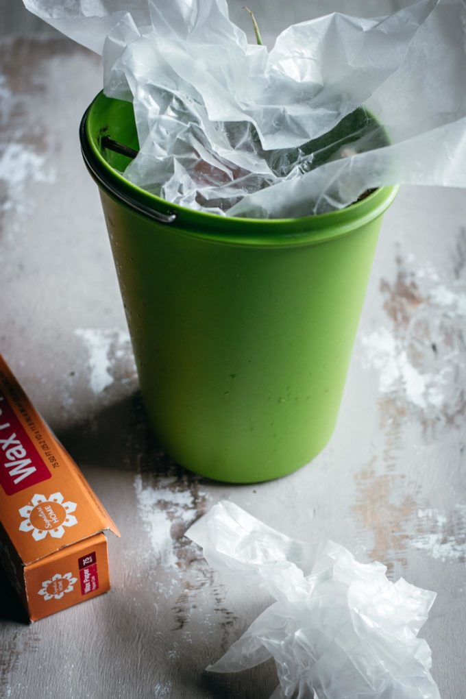 compost bin on a counter filled with crumpled wax paper