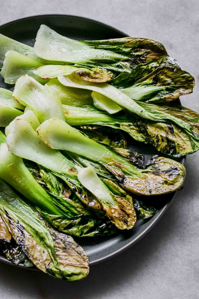 baked bok choy chips on a blue plate on a white table
