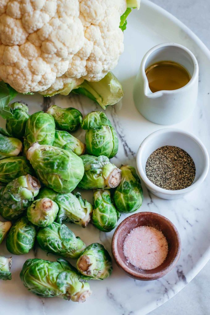 brussels sprouts, cauliflower and bowls of olive oil, salt and pepper