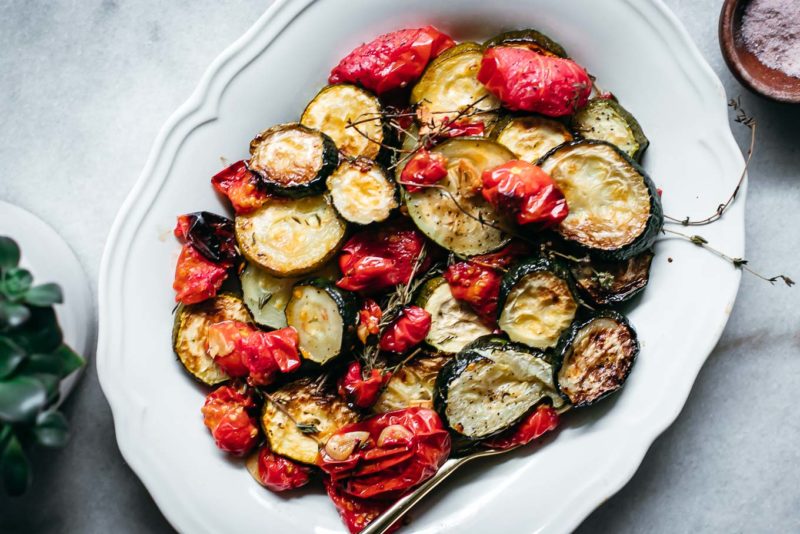 baked tomatoes and zucchini on a white plate