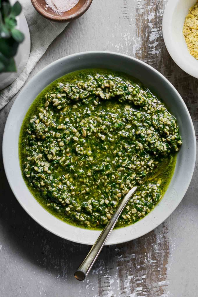 fresh vegan spinach pesto in a bowl with a gold spoon