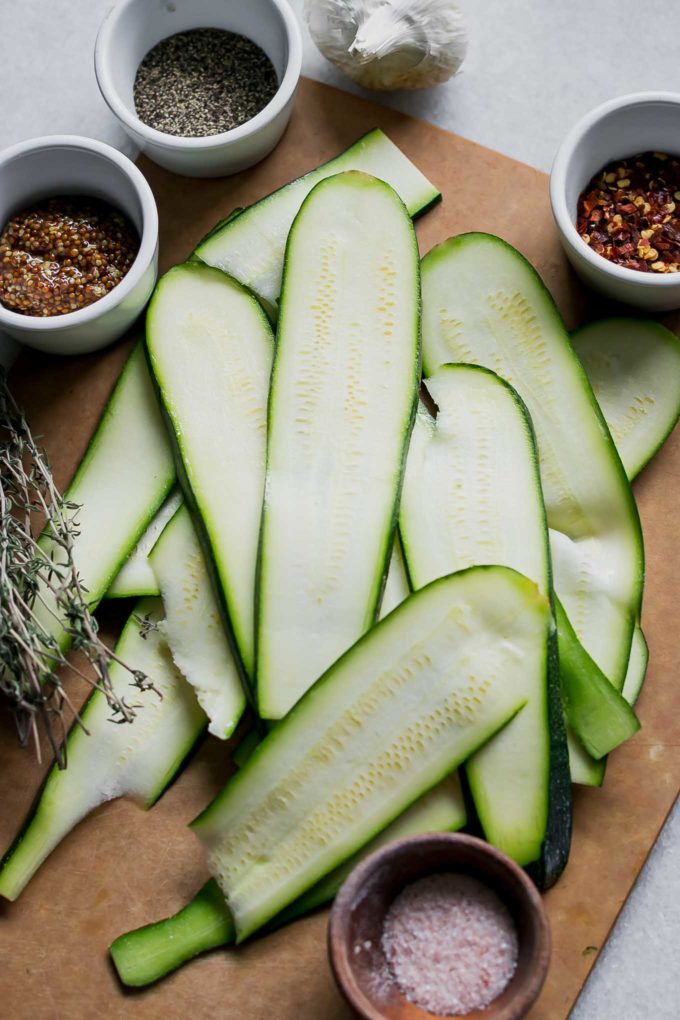 sliced zucchini strips on a cutting board on a white table