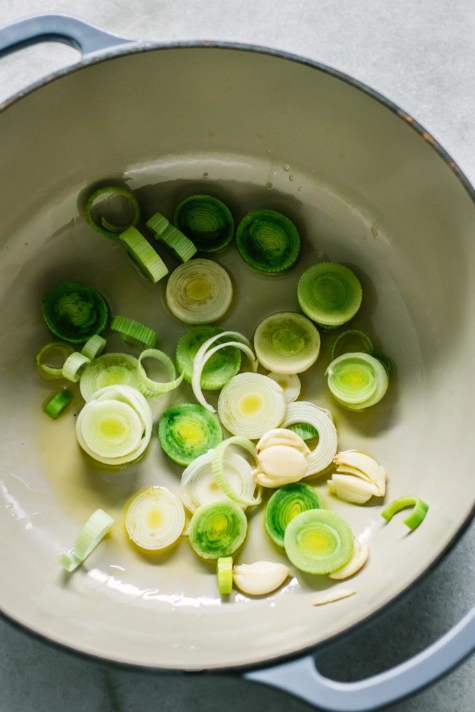 sliced leeks in a white soup pot