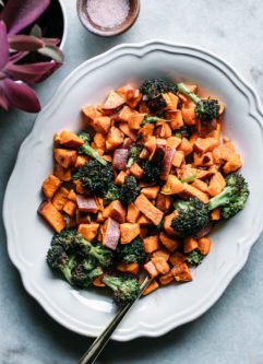 baked broccoli and sweet potatoes on a plate with a gold fork