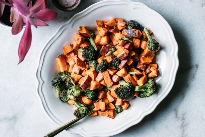 oven roasted sweet potatoes and broccoli on a white plate on a marble countertop