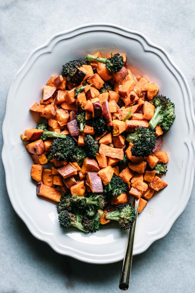 roasted sweet potatoes and broccoli side dish on a white serving plate