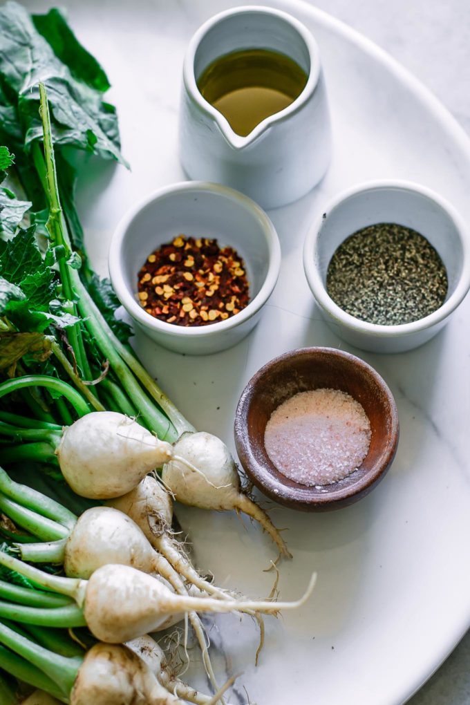 turnips, olive oil, red pepper flakes, salt and pepper on a tray