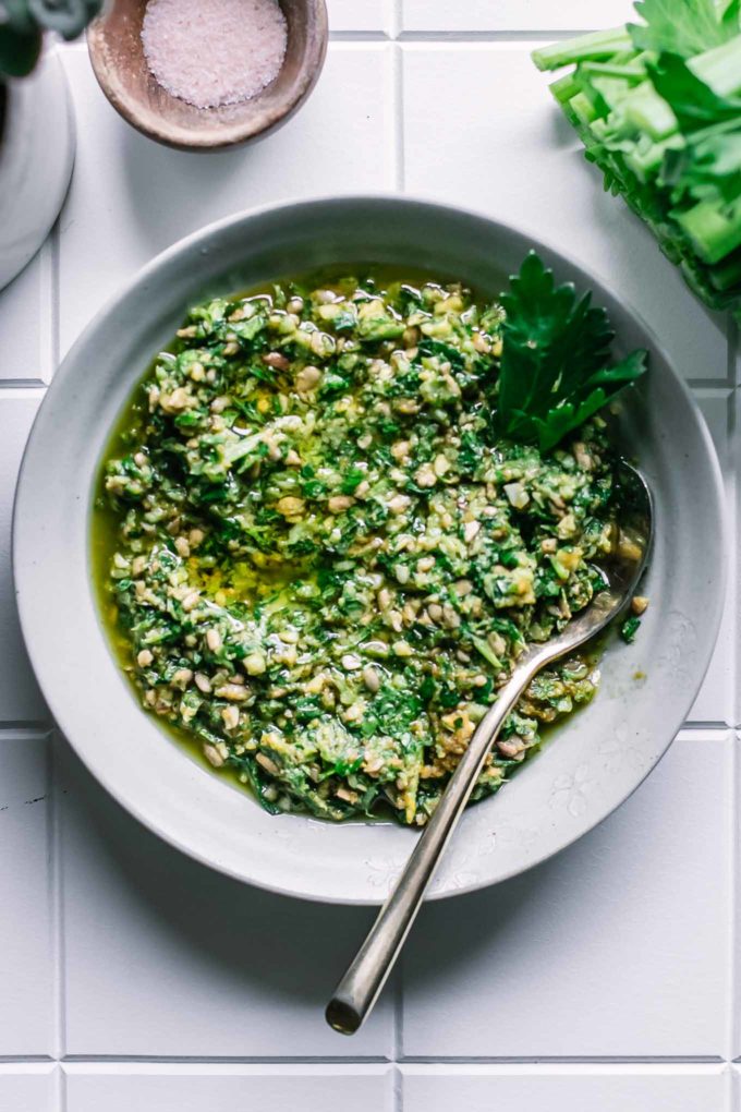 pesto with celery leaves in a bowl with a gold fork