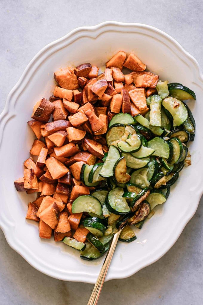 baked zucchini and sweet potato slices on a white plate on a white table