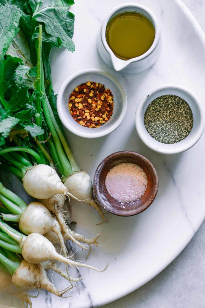 turnips, olive oil, red pepper flakes, salt and pepper on a tray