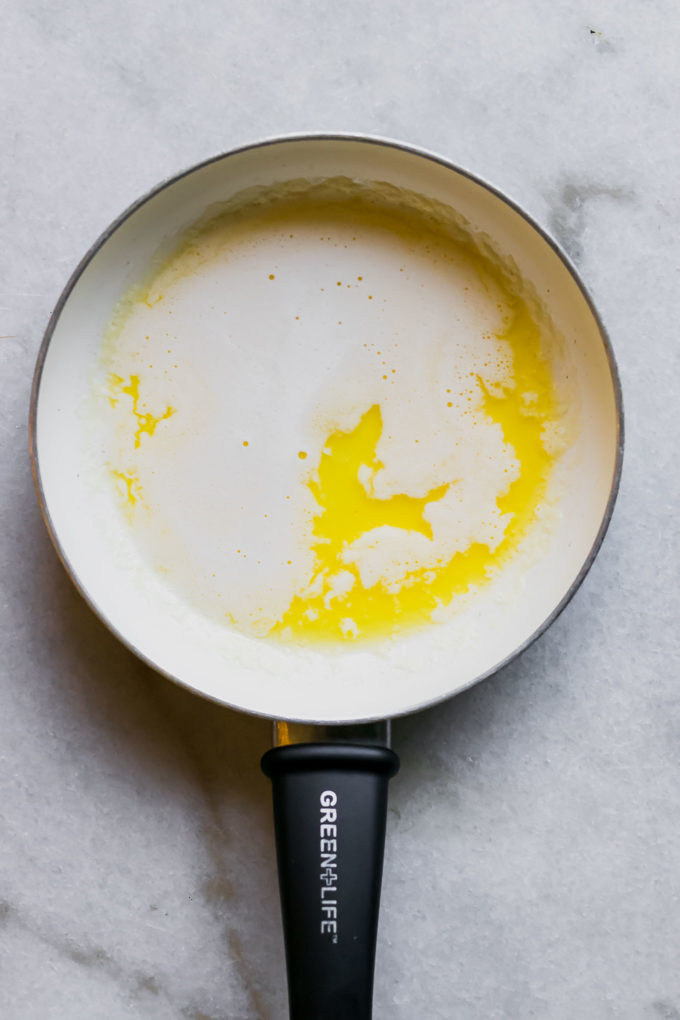 a white sauce pan with melted butter on a white countertop