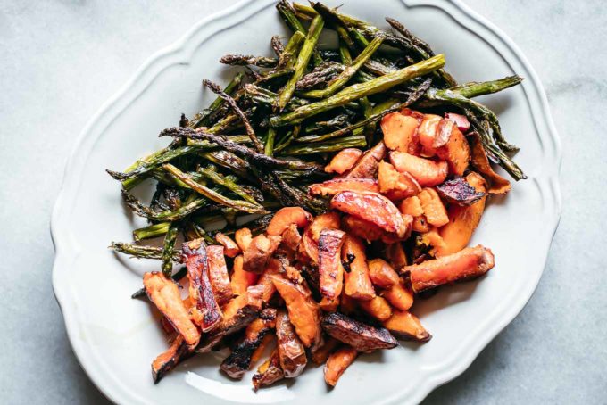 roasted sweet potatoes and sliced asparagus on a white plate