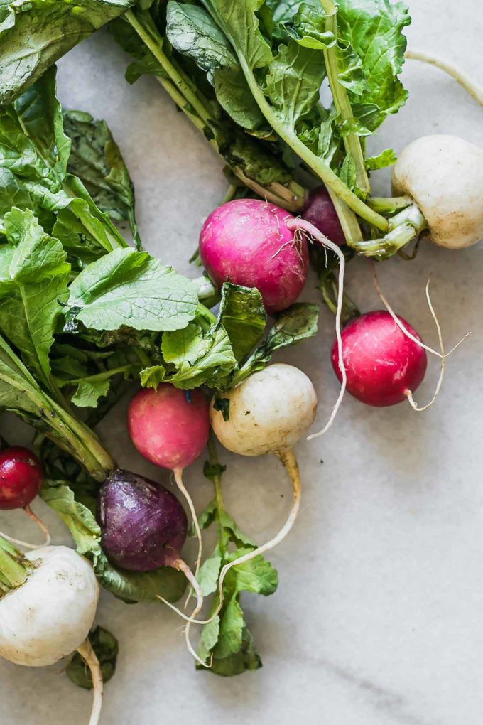 rainbow colored radishes on a white countertop