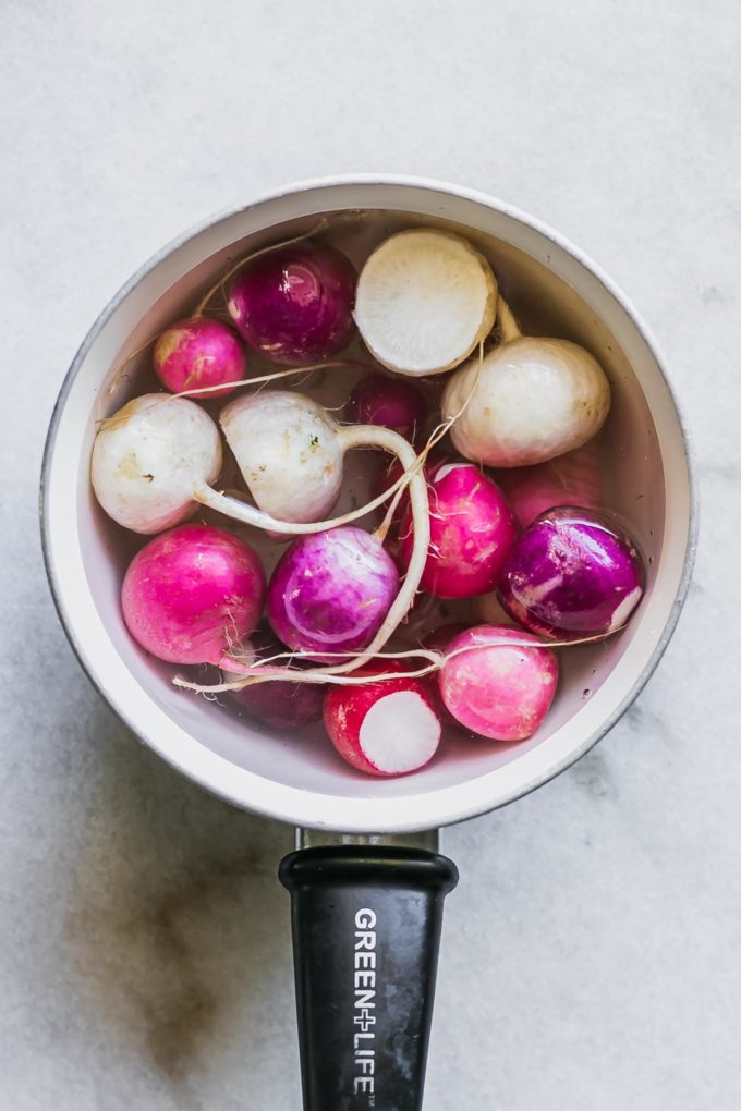radishes blanching in a a pot of boiling water