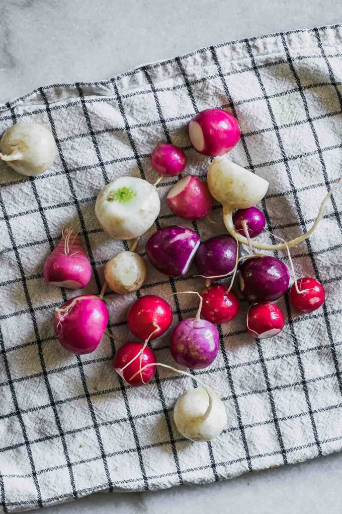 radishes drying on a kitchen towel on a white table