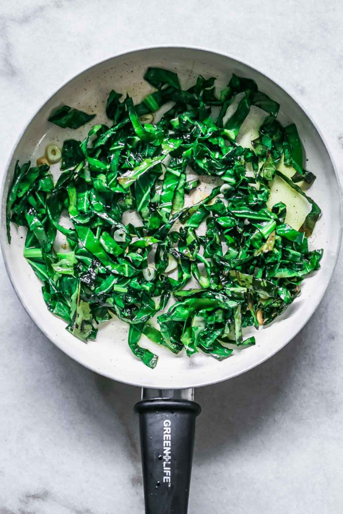 cooked brussels sprouts greens in a white pan