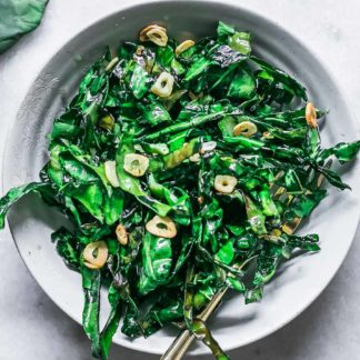 a side dish of pan fried brussels sprouts greens on a white table
