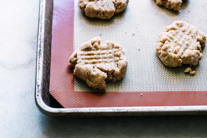 baked peanut butter cookies on a baking sheet with a silpat