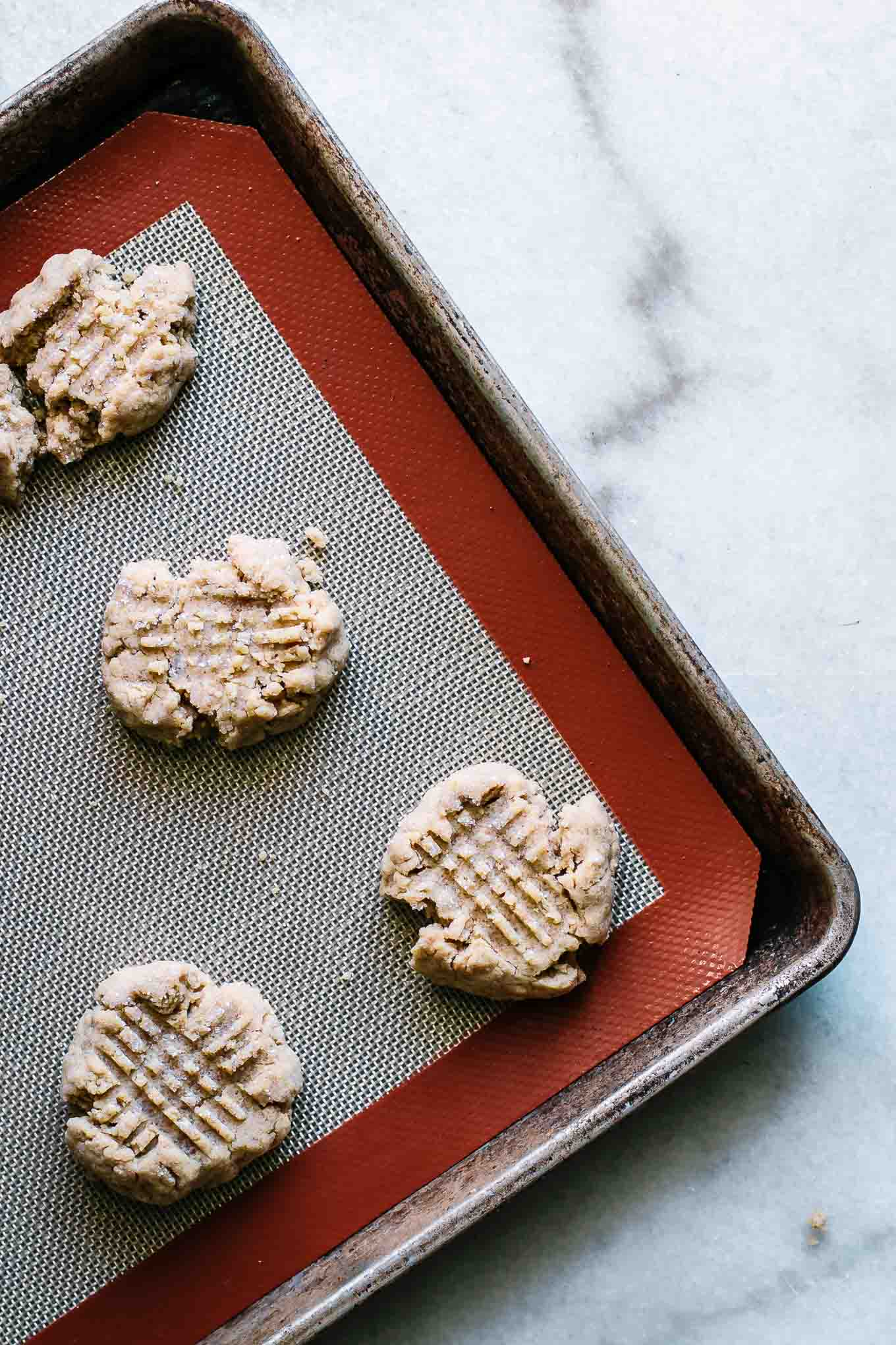 a sheet pan of baked cookies on top of a silicone baking mat