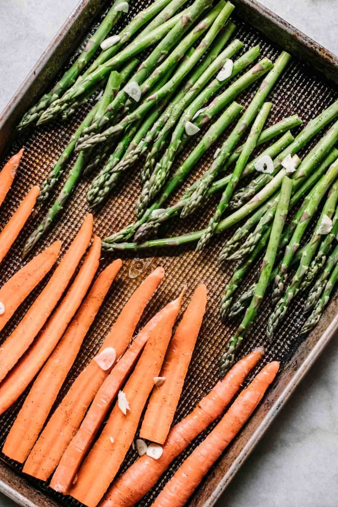 cut carrots and asparagus on a roasting pan before cooking