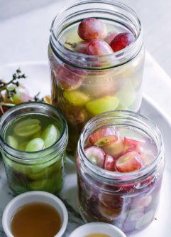 jars of grapes in pickling brine on a white table