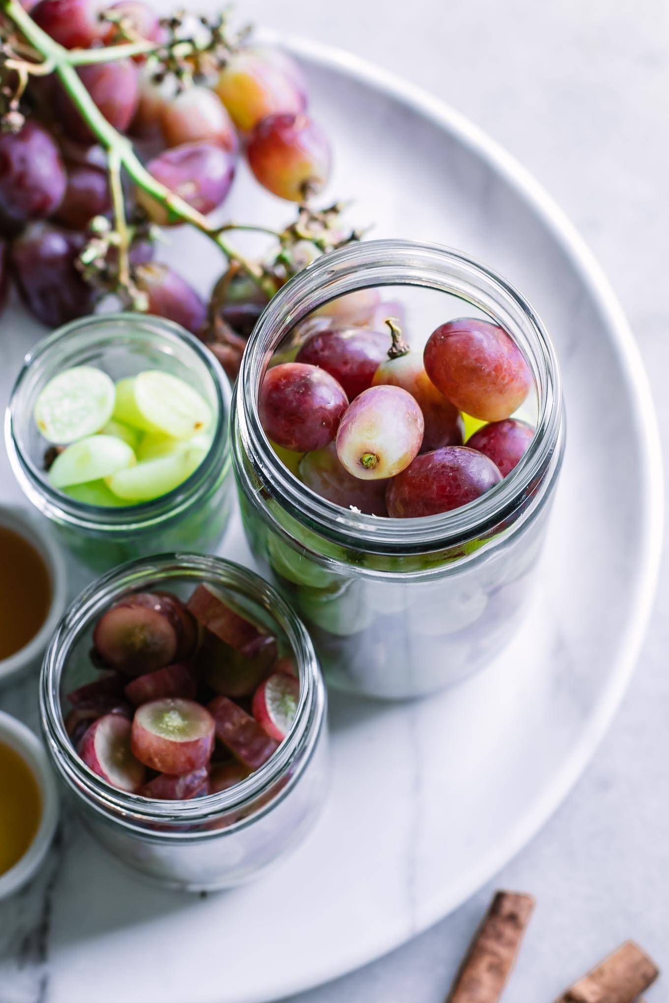 jars of grapes with pickling brine on a white table