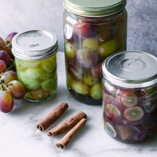 jars of quick pickled grapes on a white table
