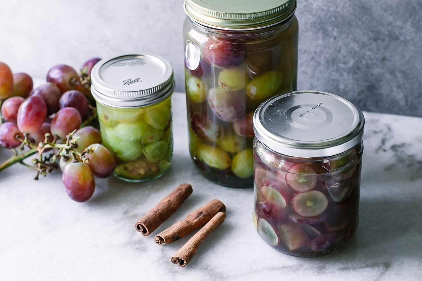 jars of quick pickled grapes on a white table