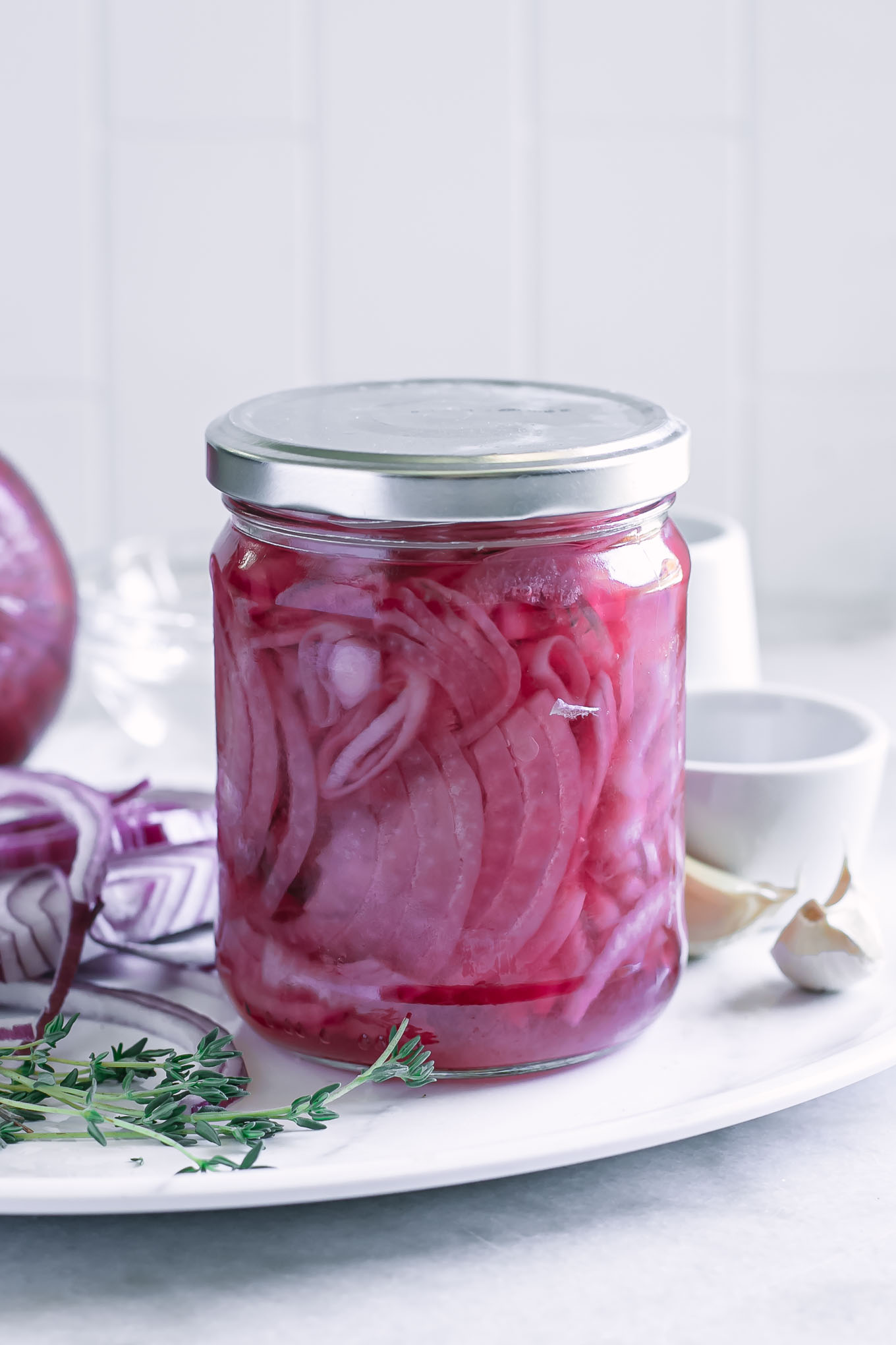 sealed jar of pickled red onions on a platter