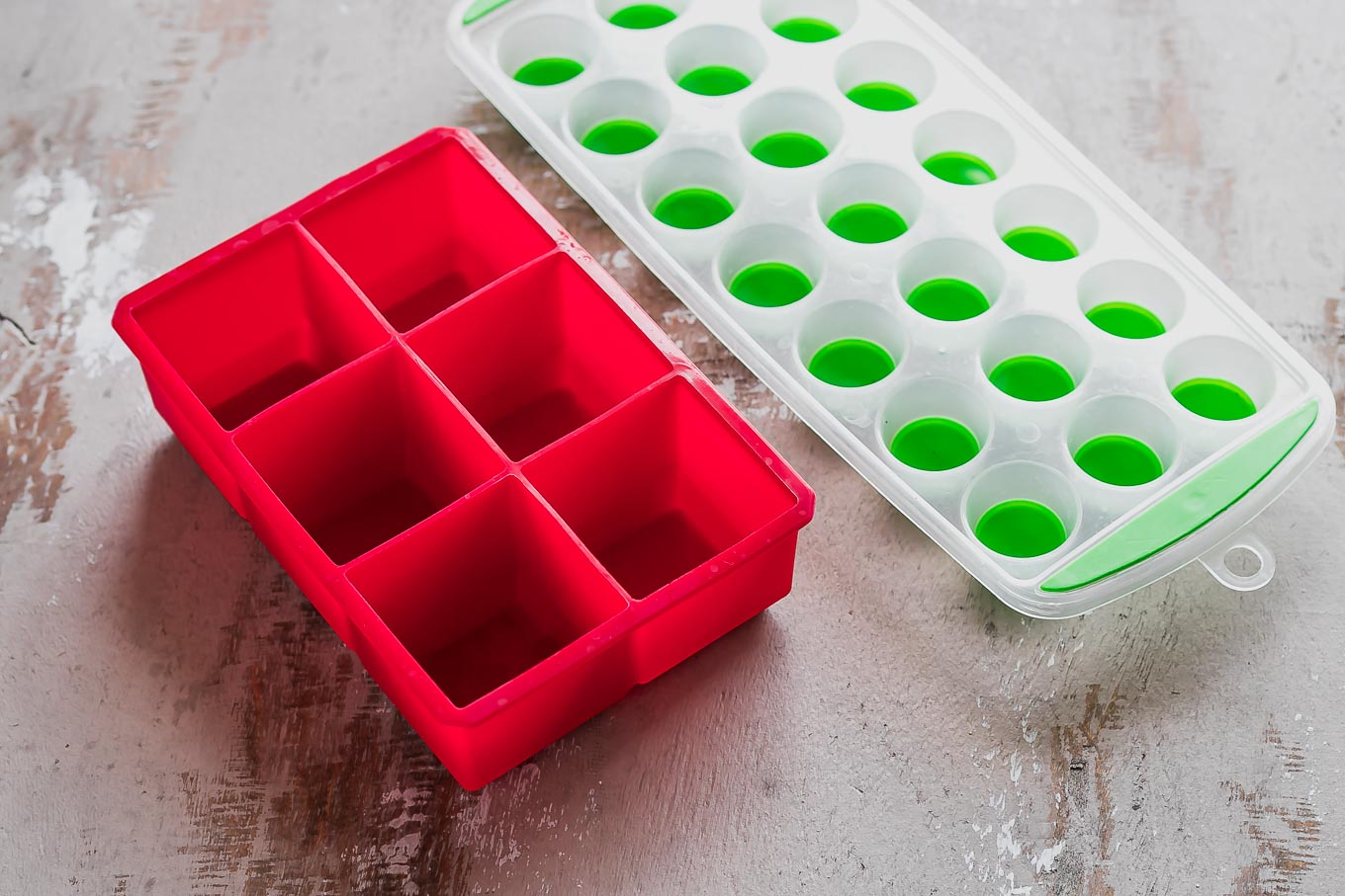 large and small silicone ice trays on a wood table