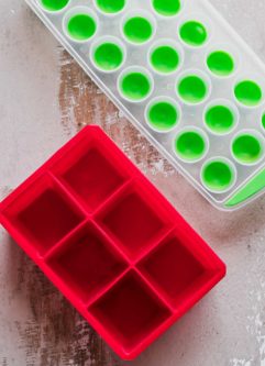 red and green silicone ice trays on a wooden table