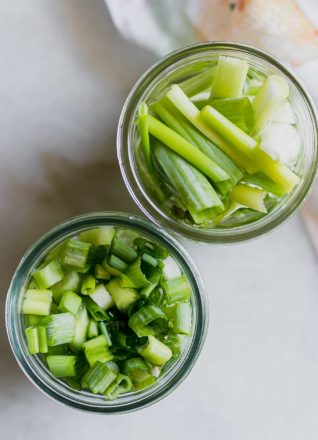 sliced and cut pickled green onions in glass jars