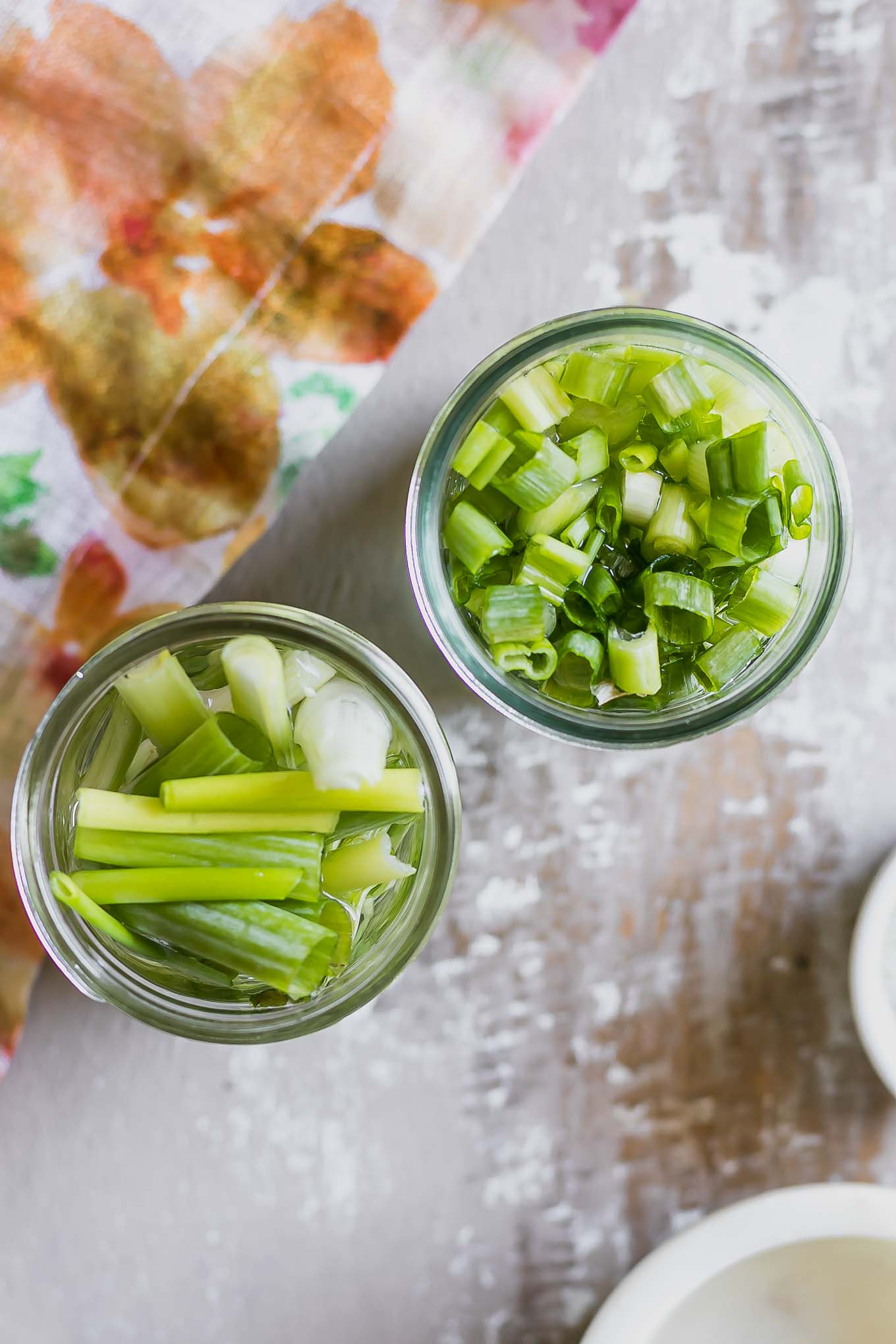 quick pickled green onions on glass jars on a wood table
