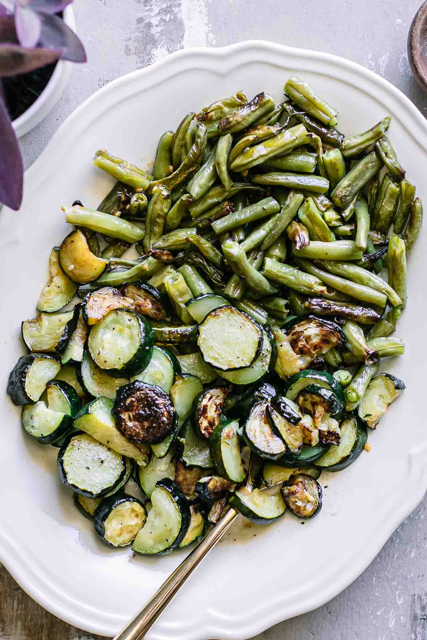 roasted zucchini and green beans side dish on a white plate