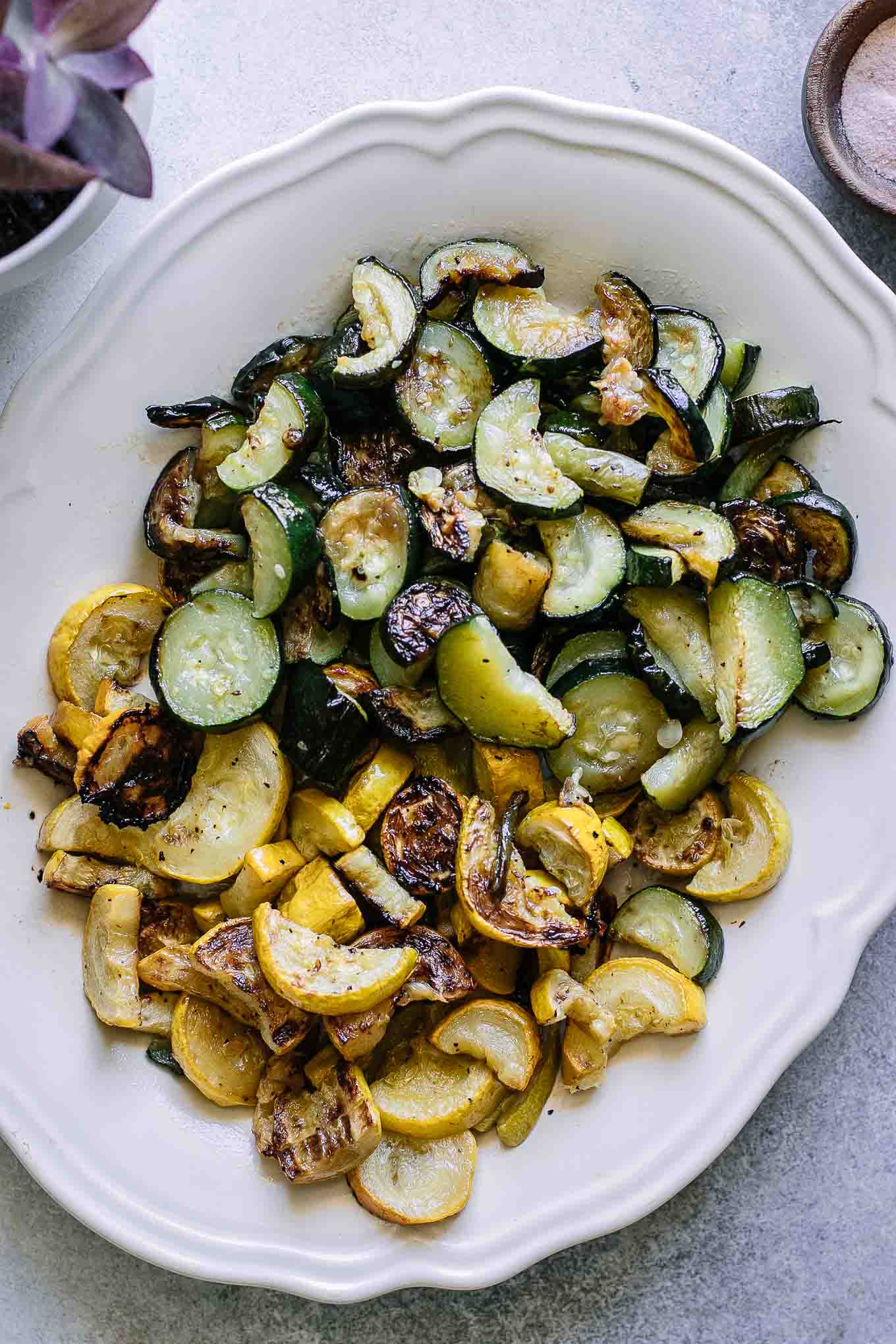 roasted sliced zucchini and yellow summer squash on a white plate