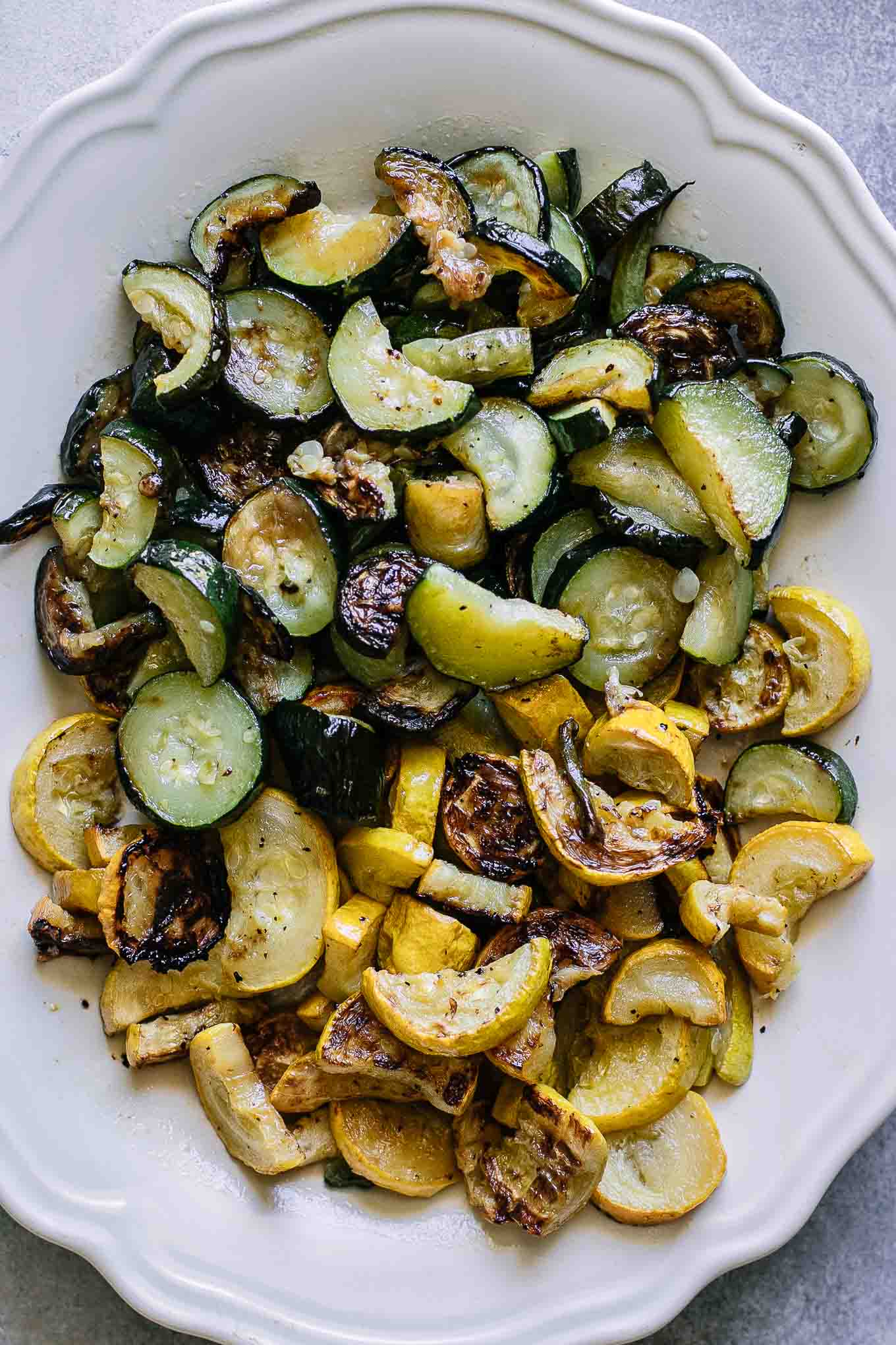 a closeup photo of white plate with roasted zucchini and squash