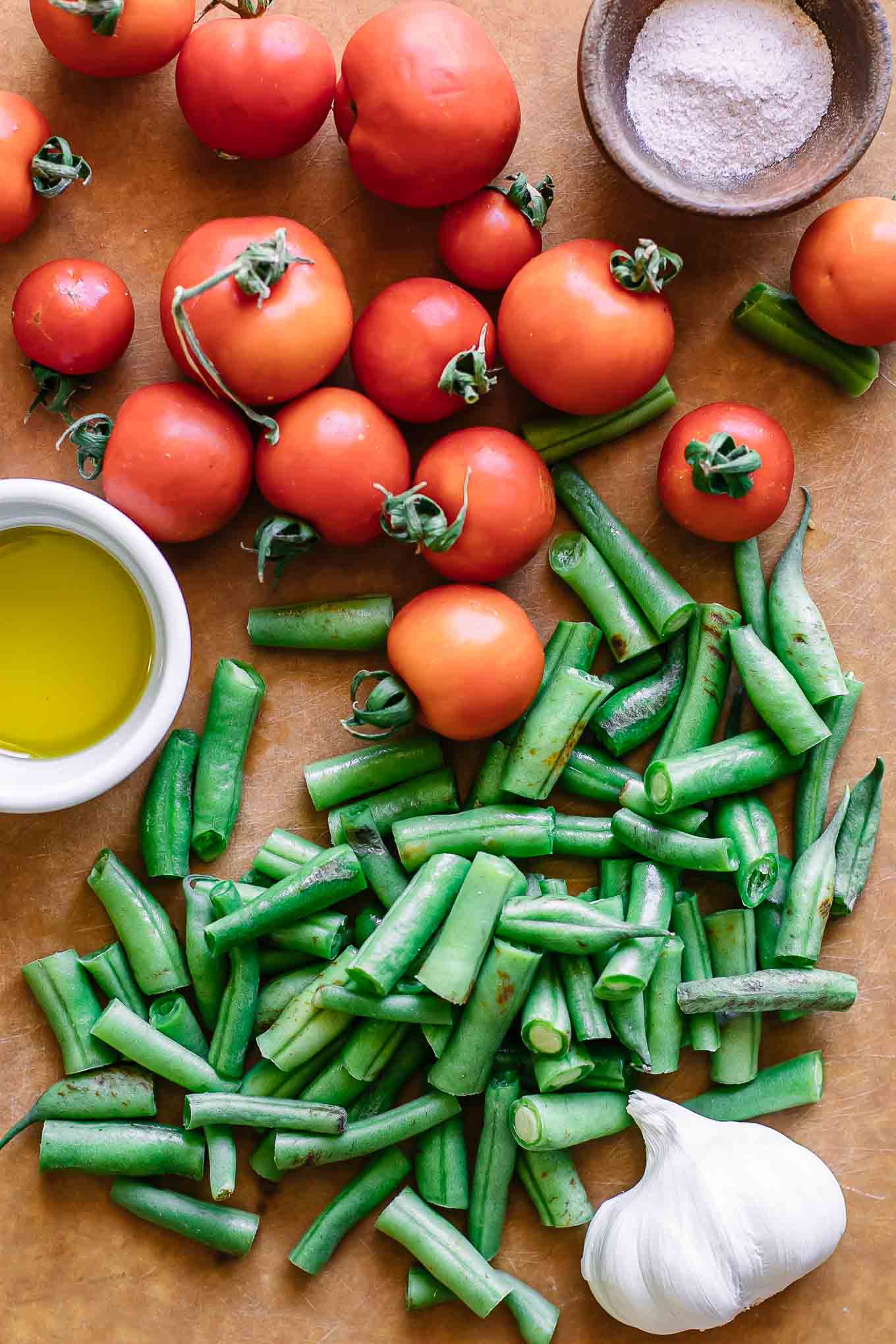 sliced tomatoes and green beans on a cutting board