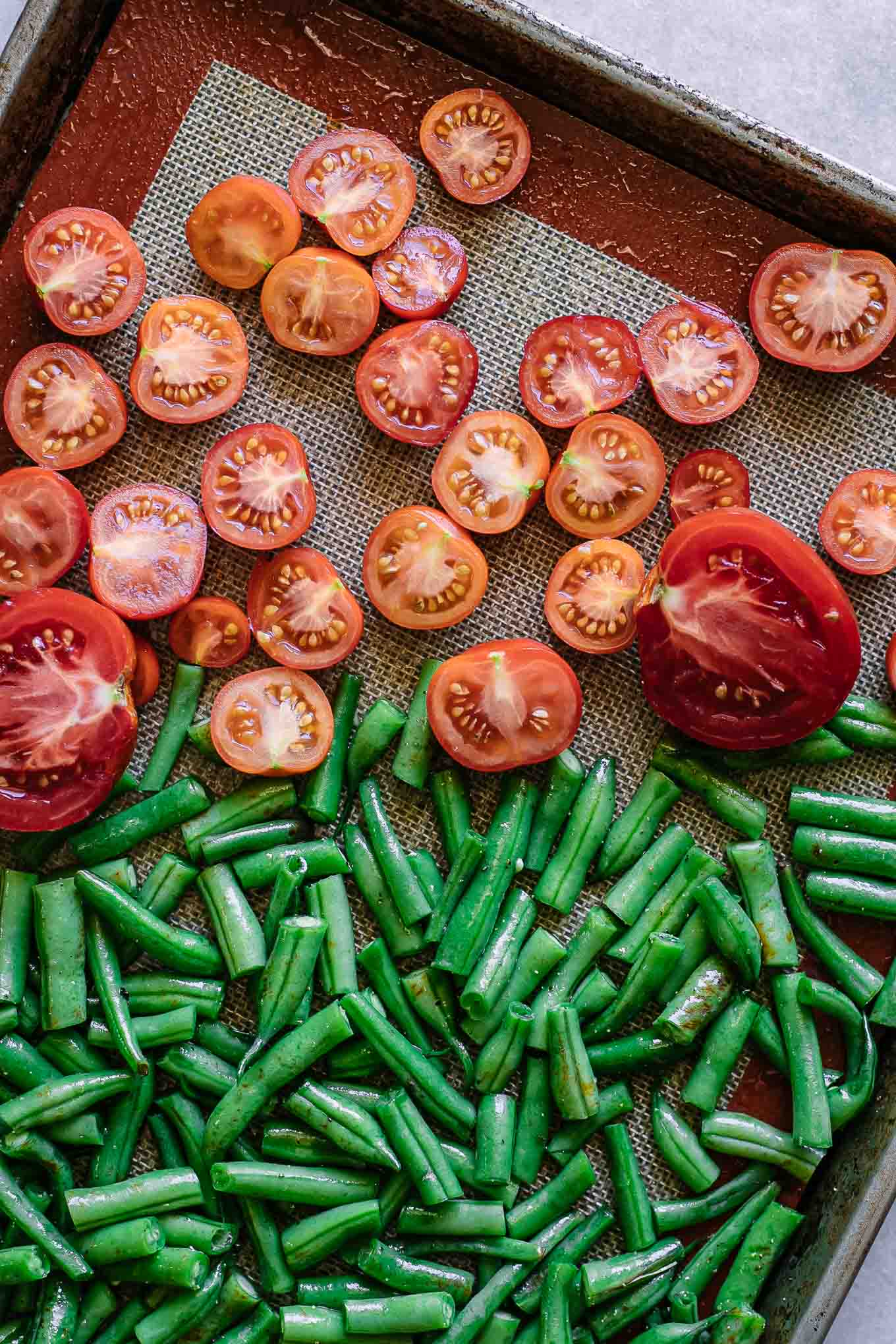 sliced green beans and tomatoes on a roasting pan