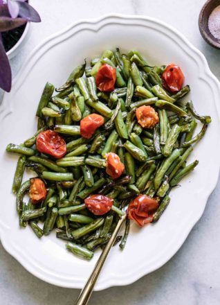 roasted green beans and tomatoes side dish on a white plate