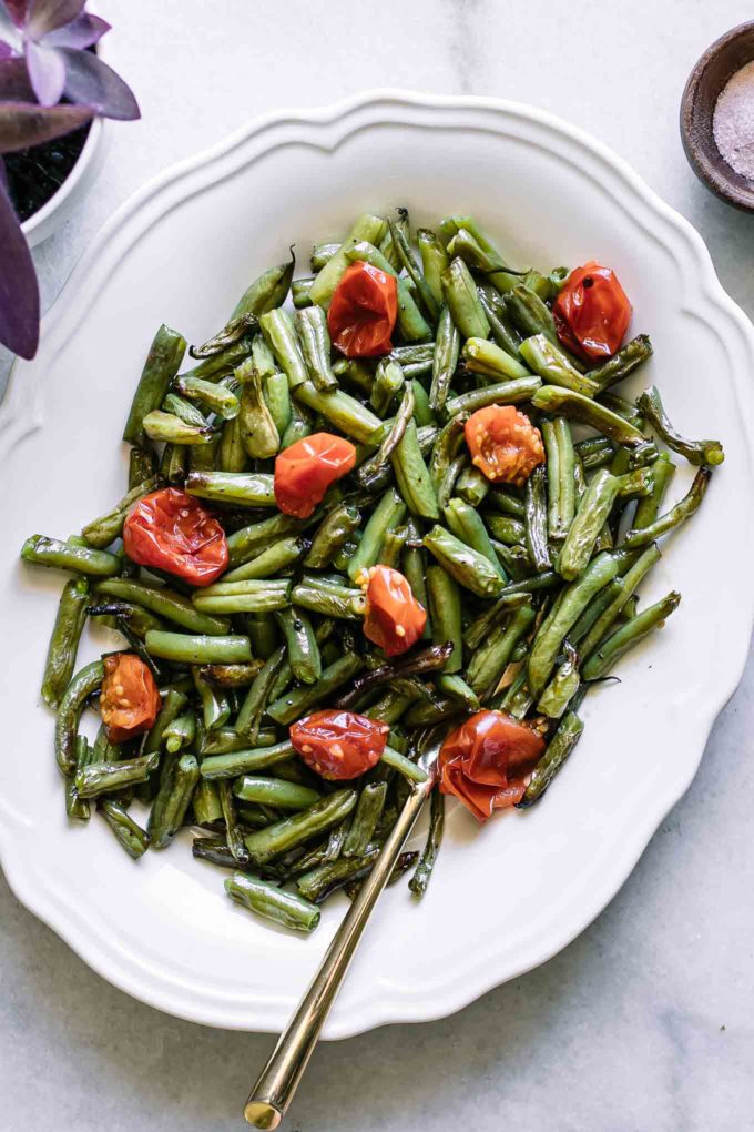 roasted green beans and tomatoes side dish on a white plate