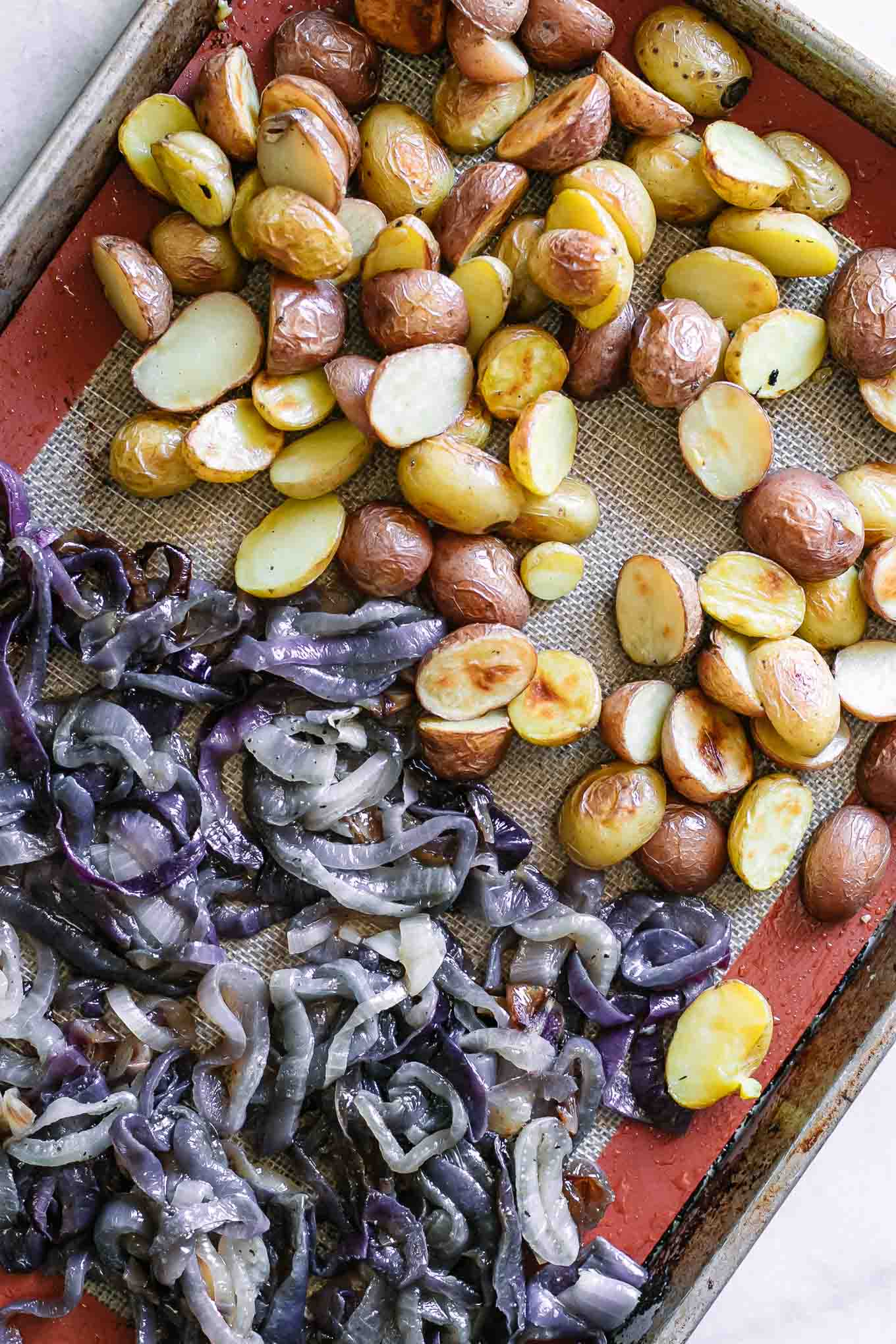 roasted onion and potatoes slices on a baking sheet after roasting