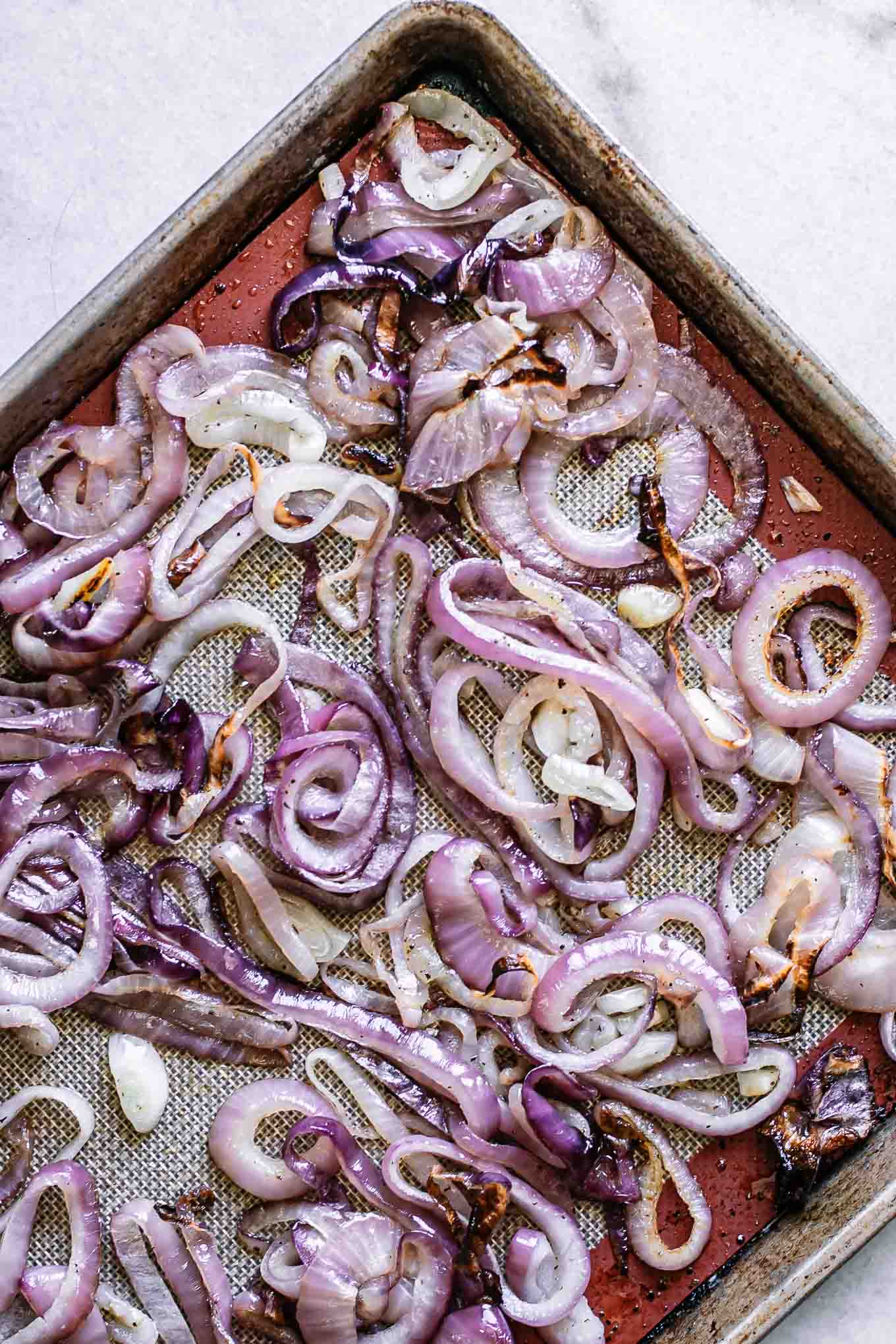 roasted red onions on a baking sheet after baking