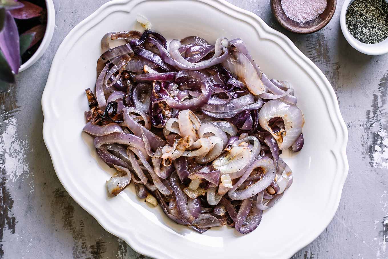 roasted red onion slices on a white plate on a white table