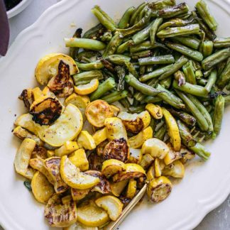 roasted summer squash and green beans on a white plate
