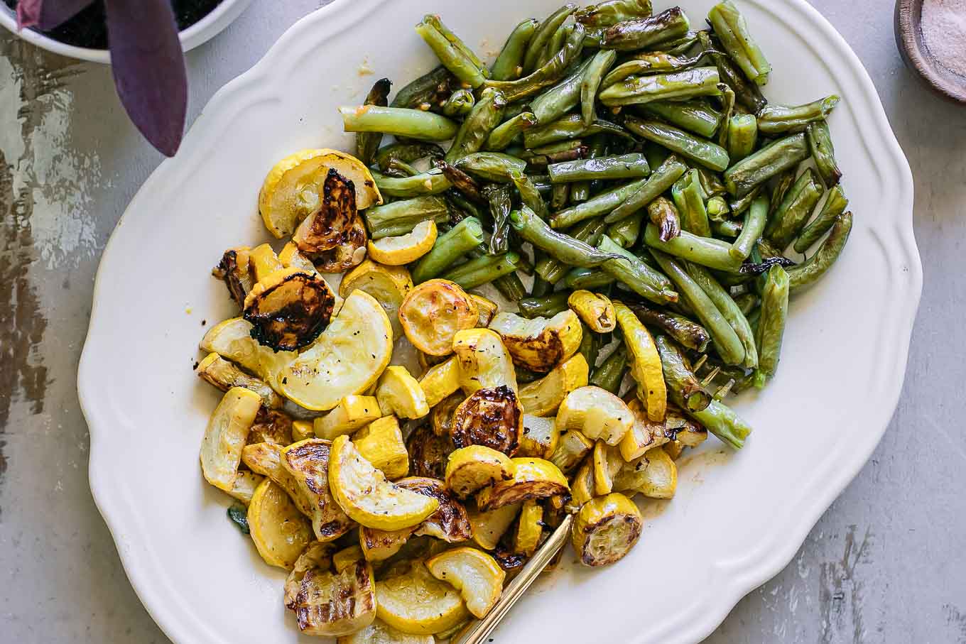 roasted summer squash and green beans on a white plate