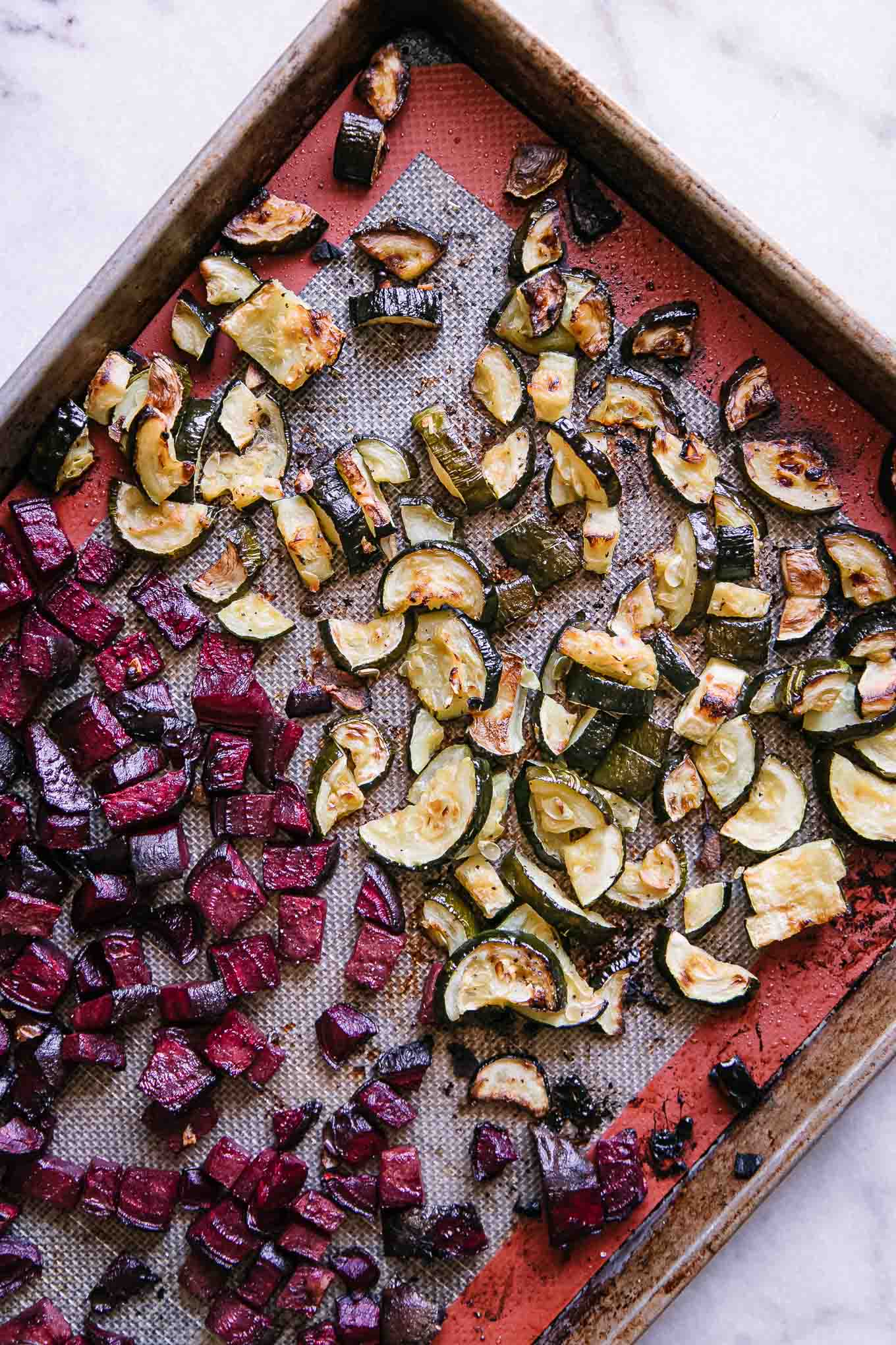 roasted zucchini and beet slices on a baking sheet after roasting