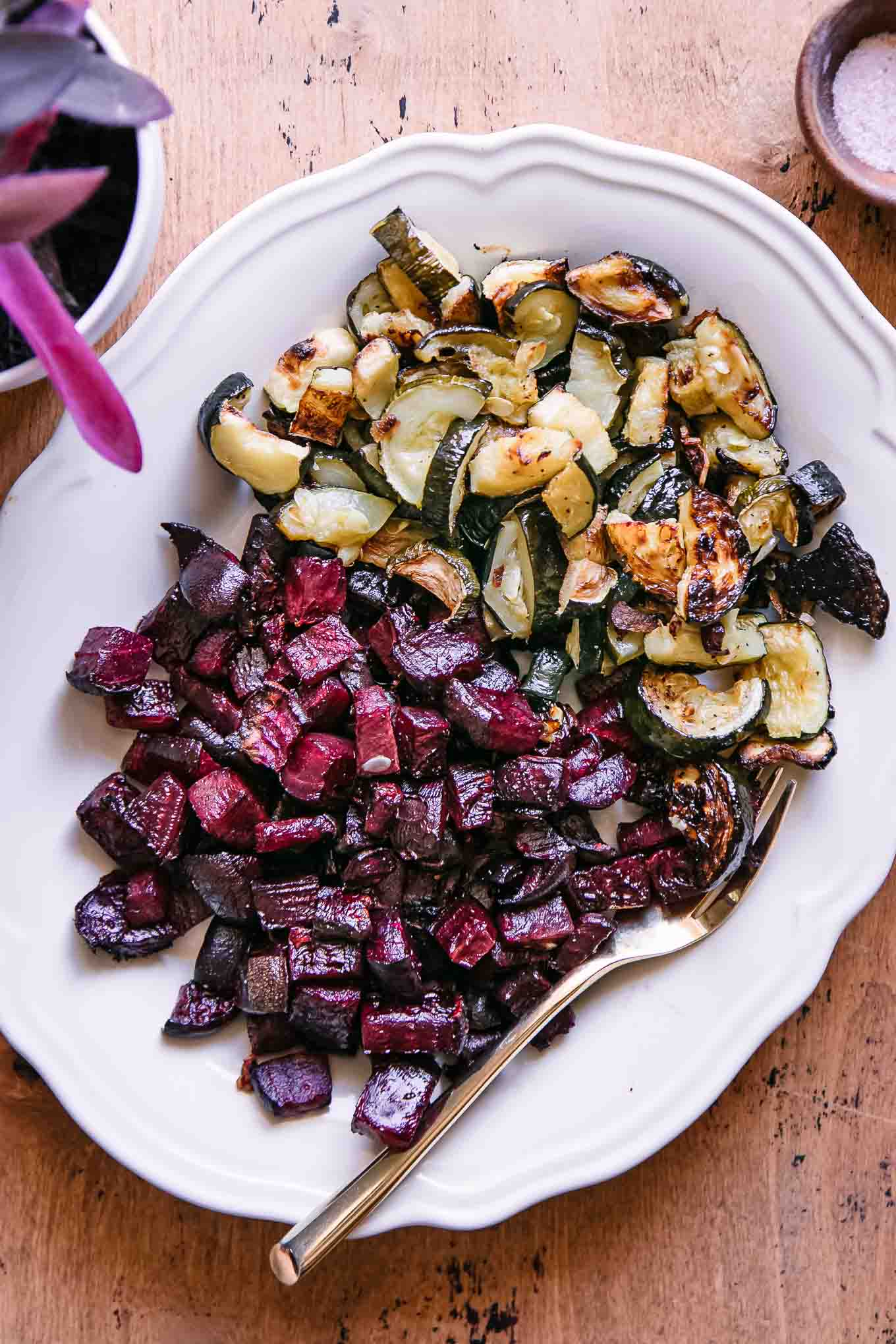 roasted beets and zucchini on a white plate with a gold fork