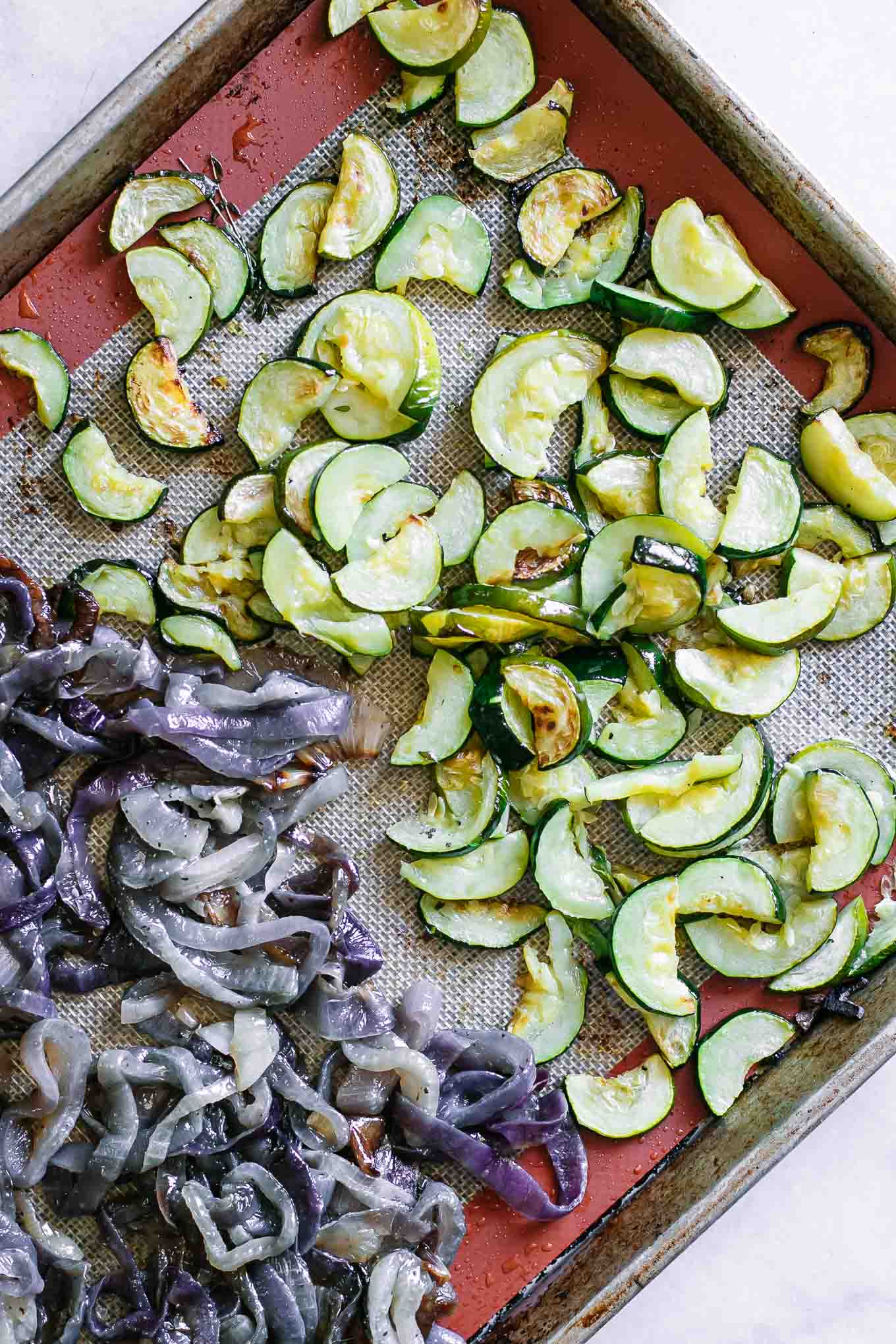 zucchini and onions on a baking sheet after roasting