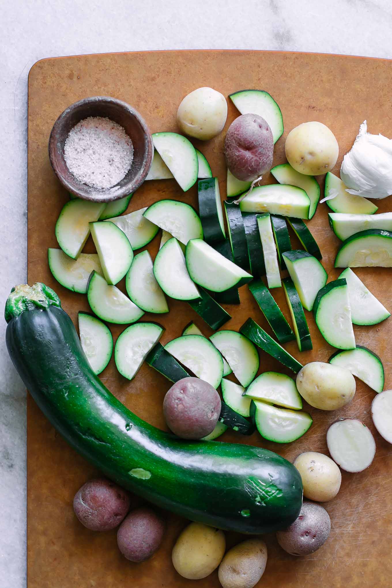 sliced zucchini and potatoes on a cutting board