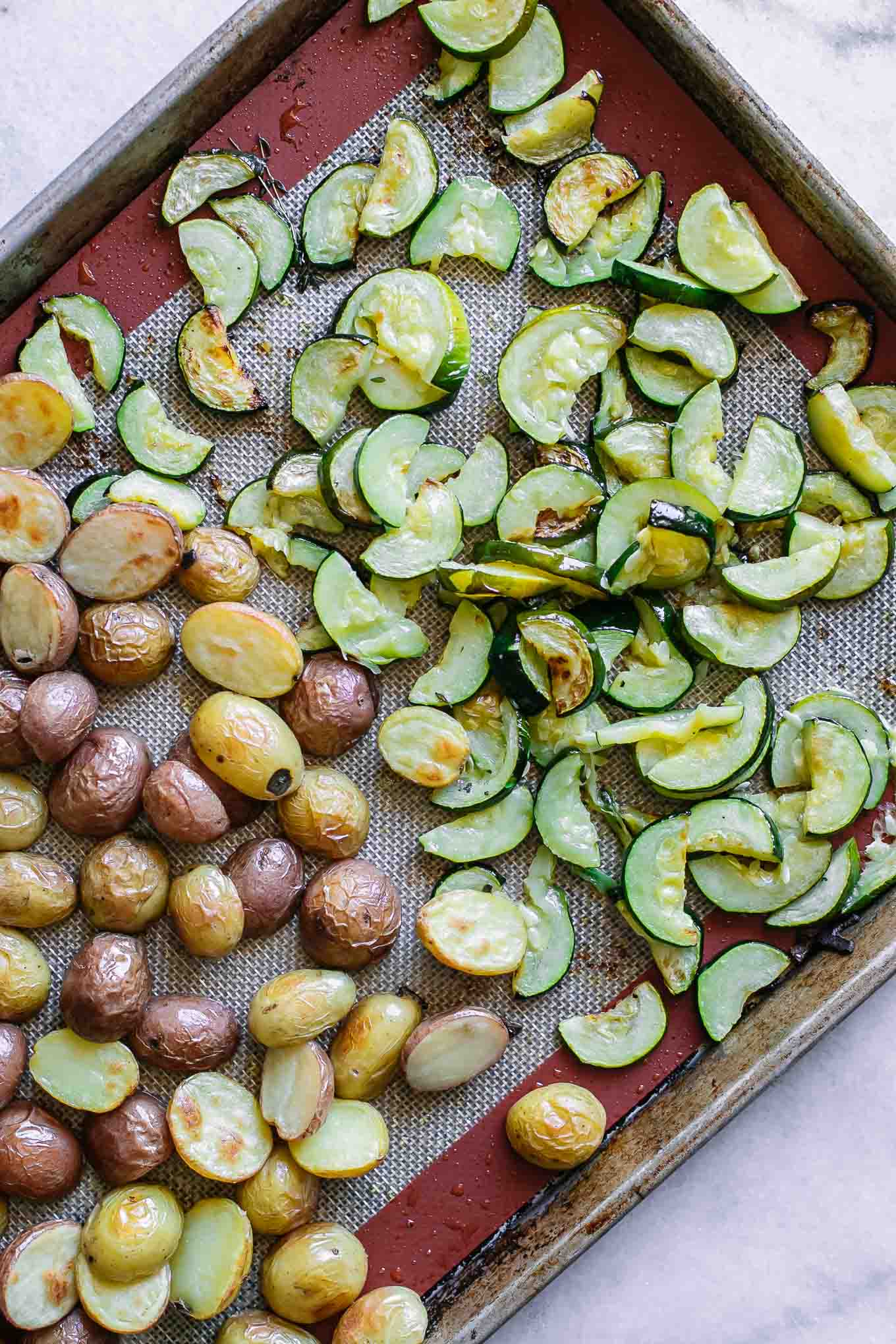 baked zucchini and potatoes on a roasting pan after baking